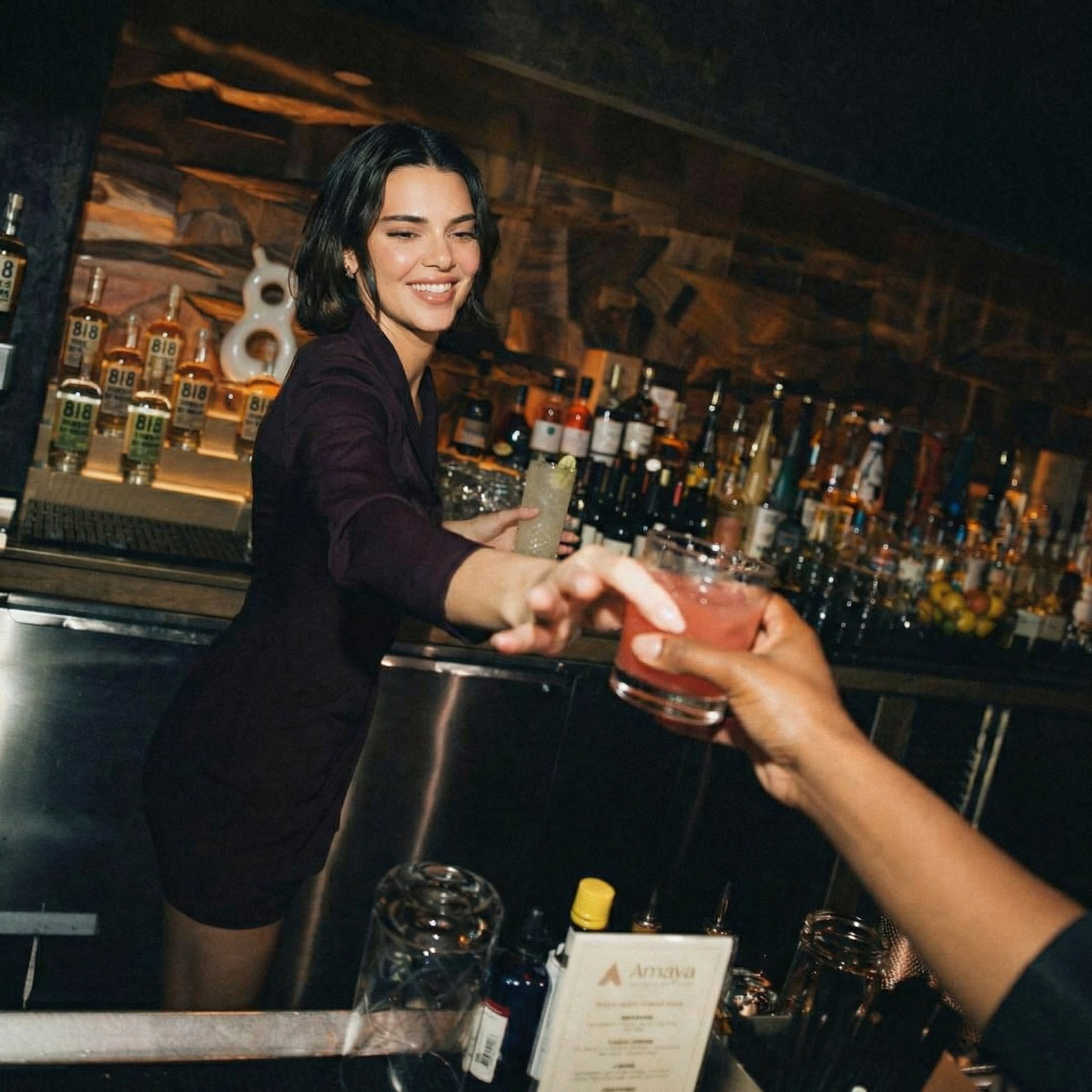 Woman serving cocktails at upscale bar with premium spirits